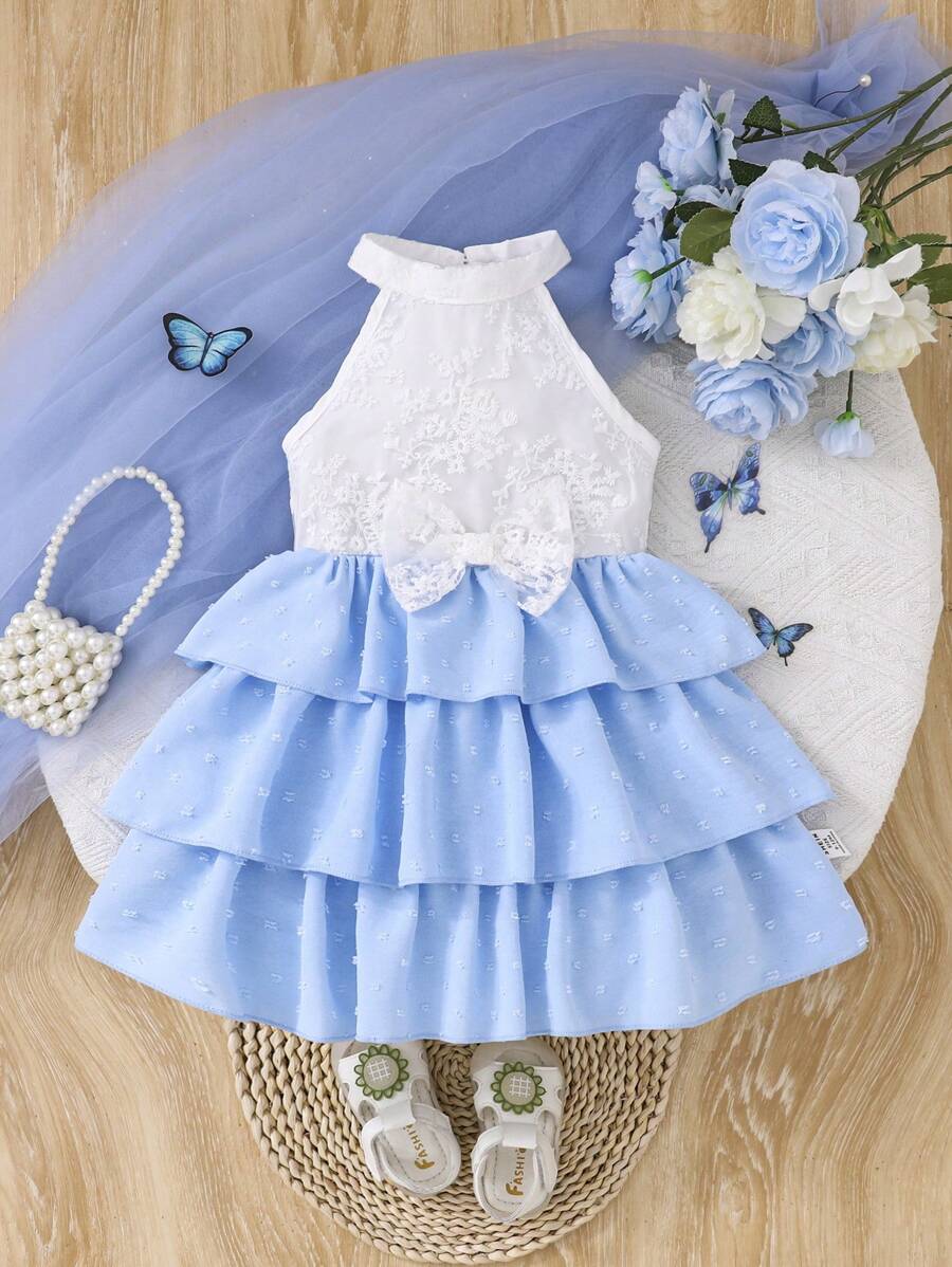 婴幼儿女孩优雅甜美休闲简约时尚吊带精致花卉刺绣蝴蝶结多层荷叶边设计白色和蓝色圆点蛋糕连衣裙，1-3 岁。整体风格既可爱又优雅，适合日常穿着、度假或拍照场合。春夏新品