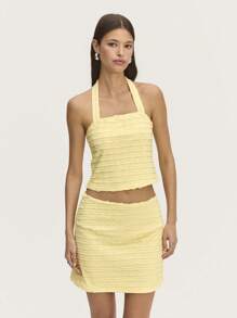 Nöista Top halter de jacquard amarillo pastel con broche de flor, diseñado para realzar tu figura. Perfecto para el verano, se combina hermosamente con la falda a juego para un look chic.