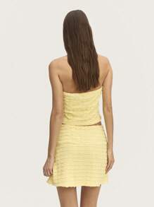 Nöista Top halter de jacquard amarillo pastel con broche de flor, diseñado para realzar tu figura. Perfecto para el verano, se combina hermosamente con la falda a juego para un look chic.