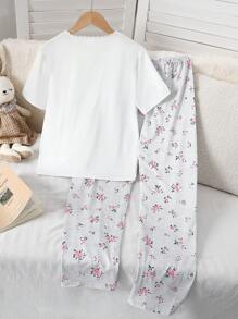 Set di pigiama per ragazza pre-adolescente, composto da top a maniche corte con colletto a bottoni, tasche in pizzo e stampa floreale grigia, e pantaloni lunghi. Outfit da relax, pigiama, set da viaggio estivo