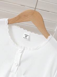 Set di pigiama per ragazza pre-adolescente, composto da top a maniche corte con colletto a bottoni, tasche in pizzo e stampa floreale grigia, e pantaloni lunghi. Outfit da relax, pigiama, set da viaggio estivo