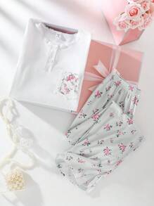 Set di pigiama per ragazza pre-adolescente, composto da top a maniche corte con colletto a bottoni, tasche in pizzo e stampa floreale grigia, e pantaloni lunghi. Outfit da relax, pigiama, set da viaggio estivo