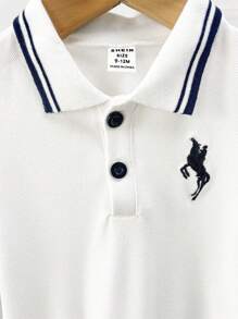 Souflis Souflis 婴儿男孩 Polo 领刺绣图案短袖 T 恤。该设计将经典 Polo 衫风格与时尚活泼的刺绣图案相结合，使其成为宝宝衣柜中的理想单品。它具有 Polo 衫的经典品质，同时添加了有趣的刺绣元素，让您的小宝贝看起来既可爱又时尚。衣领有两个纽扣，方便穿脱，增强时尚感。 - 白色 - 查看 6