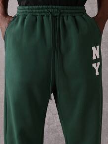 SUMWON Pantalón de chándal esencial de entrepierna caída, de ajuste recto, de rendimiento atlético, de uso diario, con cordón y logo de NY para otoño e invierno