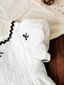 فستان فتيات صغيرات مطبوع برسوم الفراشات بأكمام منتفخة مطبوع بالكامل، مناسب للبنات الصغار للارتداء في جميع المناسبات الصيفية ، نسيج أبيض مع نمط أسود وحاشية دانتيل تجعل الطفلة تبدو أكثر فخامة وجذابة وعذبة - لون مشمشي - مشاهدة 10