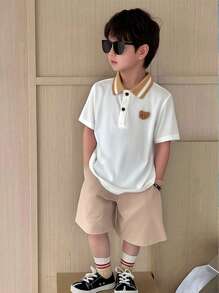 SHEIN 2pcs Toddler Boys Cute Academia Casual Cartoon Hand-Painted Teddy, Letter Embroidery Pattern Round Neck Short Sleeve White Knit Polo Shirt And Elastic Waist Khaki Comfortable Woven Shorts Set, Suitable For Outings, Home, Easter, Party, School, Vacation, Sports, Spring/Summer