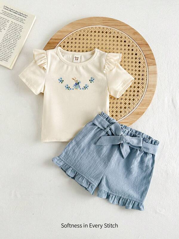 Cozy Pixies Conjunto de 2 piezas para bebé niña: blusa de manga corta con cuello redondo y volantes con diseños florales y de conejitos, y shorts con cintura elástica y decoración de moño. Conjunto informal y combinable, estilo coreano, adorable, ideal para casual, hogar y viajes.
