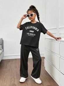 1 套女孩休闲圆领落肩 T 恤和简约条纹宽松裤，极简主义风格日常装