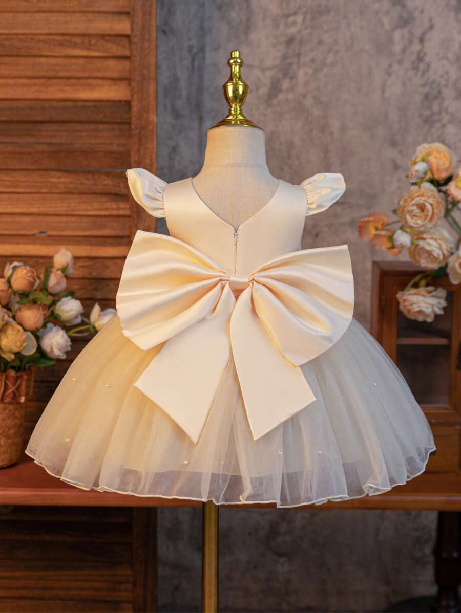 SHEIN Glamorique Kids Wedding Wedding Guest Pageboy Flower Girl Dance Dress, Baby Girl Princess Dress, Champagne Satin Small Fly Sleeves Make It Even Cuter And Playful. The Hem Is Full Of White Pearl Mesh Dress, And The Back Of The Lucky V-Shaped Detachable Satin Big Bow Is Suitable For Birthdays, Dances, Weddings, Festivals, Formal Occasions, Stage Piano Performances, Hosts, Parties Or Special Occasions. Daily Wear Baby Girl Bow Dress Baby Girl Dress Elegant Wedding Ivory Baby Dress Baby Girls Champagne Dress Satin Fall Winter