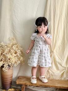SHEIN Babygirl 夏季白色田园风公主裙，以纯白色为底色，方领与小泡泡袖的设计融合了甜美可爱的元素和风格，满满的印花花朵图案栩栩如生，仿佛美丽的花海穿在身上，适合周岁典礼、婚礼、派对、沙滩、公园等，仿佛童话故事里的小公主 - 白色 - 查看 3