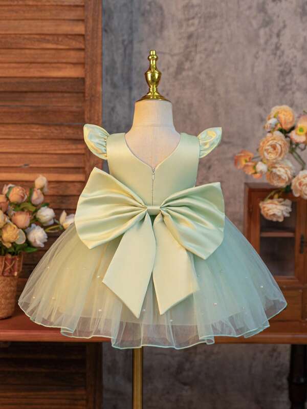 SHEIN Glamorique Kids Vestido de fiesta, boda, niña de las flores, vestido de princesa para bebé niña, de satén verde con pequeñas mangas vuelo que lo hacen aún talla grande lindo y juguetón. El dobladillo está lleno de un vestido de malla de perlas blancas, y la parte de atrás tiene un gran lazo de satén en forma de V desmontable, apropiado para cumpleaños, bailes, bodas, festivales, ocasiones formales, actuaciones en piano, anfitrionas, fiestas u ocasiones especiales. Para uso diario.