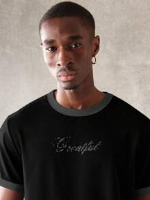 SUMWON Camiseta gráfica de estilo urbano moderno con logotipo de texto relajado, cuello de tripulación de mezcla de algodón, prenda esencial de verano para vestimenta urbana casual