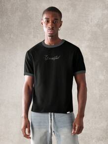 SUMWON Camiseta gráfica de estilo urbano moderno con logotipo de texto relajado, cuello de tripulación de mezcla de algodón, prenda esencial de verano para vestimenta urbana casual