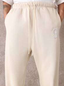 SUMWON Pantalón de chándal premium con pretina caída, números de equipo y detalles, cómodo ajuste para hacer ejercicio y uso casual en todas las estaciones