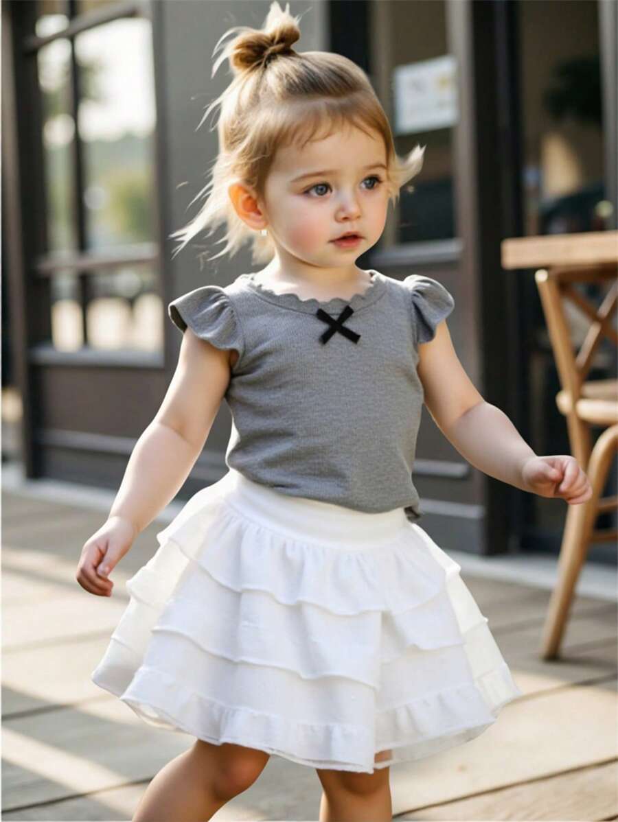 مجموعة تي شيرت وتنورة بيضاء للبنات الصغيرات في الصيف ، مناسب للاستخدام اليومي، تي شيرت رمادي مع فيونكة والتنورة البيضاء قطعتان