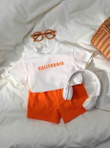 SHEIN Set de 2 piezas de ropa informal deportiva para niño/niña, estilo urbano con estampado de letras, que incluye una camiseta holgada de punto de cuello redondo y unos pantalones cortos de cintura elástica, apta para usar en primavera/verano tanto en casa como al aire libre