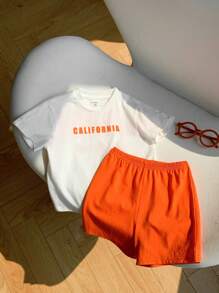 SHEIN Set de 2 piezas de ropa informal deportiva para niño/niña, estilo urbano con estampado de letras, que incluye una camiseta holgada de punto de cuello redondo y unos pantalones cortos de cintura elástica, apta para usar en primavera/verano tanto en casa como al aire libre