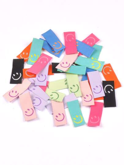 50 piezas de etiquetas de ropa con estampado de caras sonrientes de dibujos animados multicolor. Se pueden coser en la ropa. Accesorio de ropa DIY