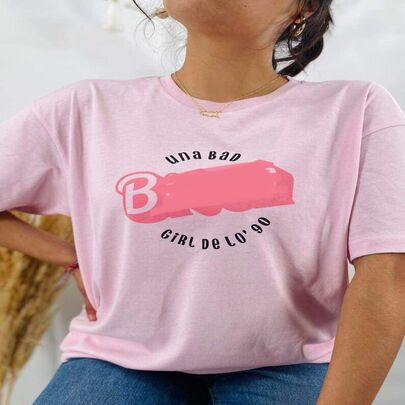 Playera rosa de hombros caídos tipo oversized con estampado (tachado para su publicación) en letras una Bad Bi*** Girl de los 90
