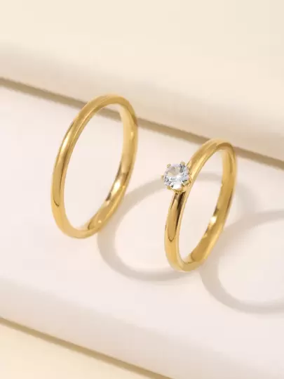 两枚不锈钢简约精致金色情侣订婚戒指，适合女性日常佩戴或求婚。