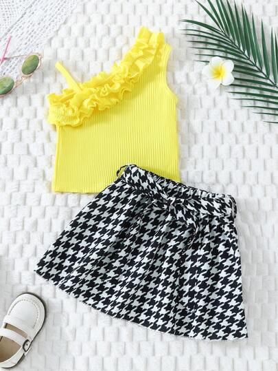 年輕女孩不對稱領口上衣,配饗紋擺飾和八字格花紋裙子套裝