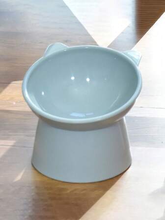 1只可愛的藍色寵物碗,擁有抗黑啞和傾斜提升碗的特點,適用於狗和貓,並配有防濺設計,材質為塑料