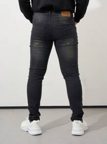 Los jeans ajustados negros con bordes rotos para hombre son casuales