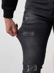 Los jeans ajustados negros con bordes rotos para hombre son casuales
