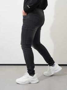 Los jeans ajustados negros con bordes rotos para hombre son casuales