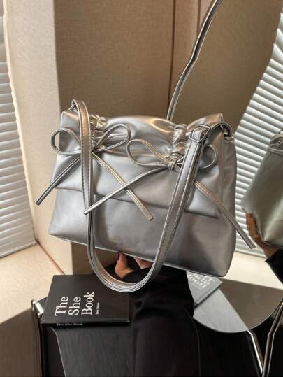 黑色蝴蝶结装饰抽绳褶皱蝴蝶结PU材质翻盖拉链单肩包，配有可调节肩带，适合日常通勤装扮。