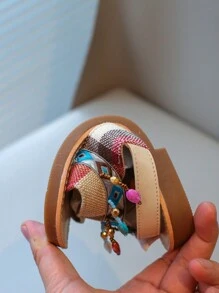 Nouvelles sandales pour enfants en bas doux de style national à la mode avec pendentif croix et pompon, que peuvent porter des amis ou des membres de la famille pour les vacances, les loisirs ou des activités en plein air.