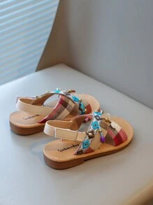 Nouvelles sandales pour enfants en bas doux de style national à la mode avec pendentif croix et pompon, que peuvent porter des amis ou des membres de la famille pour les vacances, les loisirs ou des activités en plein air.