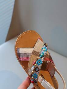 Nouvelles sandales pour enfants en bas doux de style national à la mode avec pendentif croix et pompon, que peuvent porter des amis ou des membres de la famille pour les vacances, les loisirs ou des activités en plein air.
