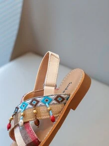 Nouvelles sandales pour enfants en bas doux de style national à la mode avec pendentif croix et pompon, que peuvent porter des amis ou des membres de la famille pour les vacances, les loisirs ou des activités en plein air.