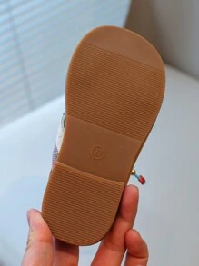Nouvelles sandales pour enfants en bas doux de style national à la mode avec pendentif croix et pompon, que peuvent porter des amis ou des membres de la famille pour les vacances, les loisirs ou des activités en plein air.