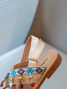 Nouvelles sandales pour enfants en bas doux de style national à la mode avec pendentif croix et pompon, que peuvent porter des amis ou des membres de la famille pour les vacances, les loisirs ou des activités en plein air.
