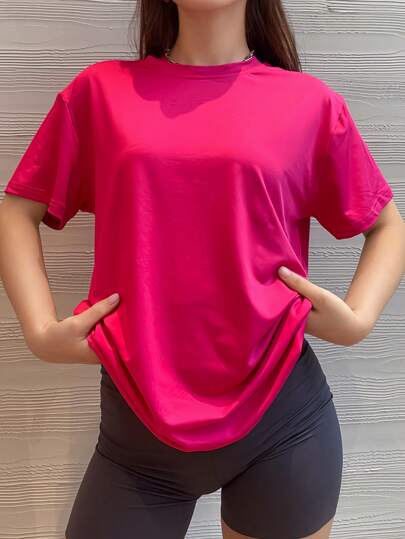 Camiseta básica holgada y casual de color rosa intenso con mangas cortas y caída de hombros pequeña