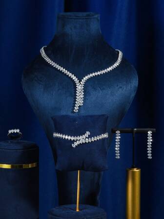 1 件闪亮的铜底新娘婚礼项链，镶嵌闪亮的锆石 + 1 件奢华的锆石新娘婚礼手链，镀层持久 + 1 对时尚的锆石新娘婚礼耳环 + 1 件优雅的锆石新娘结婚戒指。5 件套时尚婚礼配饰，适合派对、婚礼、晚会和新娘拍照。万圣节