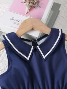 Giovane ragazza Vestito Vintage senza maniche con colletto a camicia oxford, vita cinturata e orlo plissettato a contrasto di colore, estate