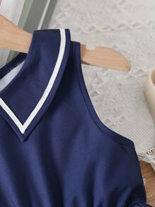 Giovane ragazza Vestito Vintage senza maniche con colletto a camicia oxford, vita cinturata e orlo plissettato a contrasto di colore, estate