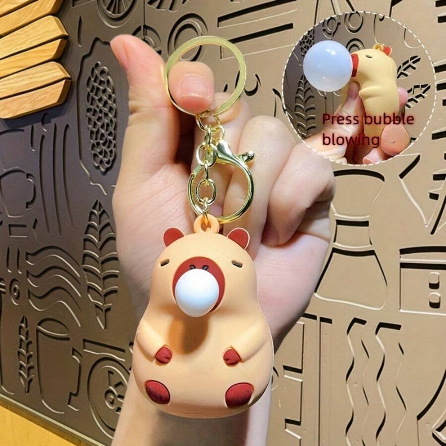 1 pieza Llavero de figura de capibara soplando burbujas de estilo lindo y delicado, hecho de material de silicona suave y cómodo, divertido y de alivio de tensión - color brillante - Ver 1