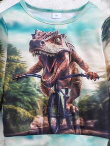Set deportivo de 2 piezas para niños pequeños con top de manga larga con estampado 3D de niños montando bicicleta con dinosaurio y pantalones de unicolor - Verde militar - Ver 3