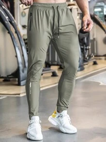 Pantalon de jogging casual d'été pour hommes, avec poches zippées, taille ajustable et détail réfléchissant. Confortable et extensible.