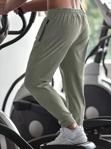 Pantalon de jogging casual d'été pour hommes, avec poches zippées, taille ajustable et détail réfléchissant. Confortable et extensible.