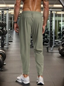 Pantalon de jogging casual d'été pour hommes, avec poches zippées, taille ajustable et détail réfléchissant. Confortable et extensible.