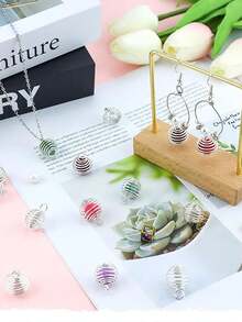 10件螺旋珠笼吊坠，不锈钢材质，您可以将水晶、火山珠、毛线球等珠子放入珠笼中，制作成项链、手链、耳环和其他精美的工艺品。DIY珠宝的最佳选择。这些螺旋珠笼吊坠可放置水晶和珠子，适合制作项链、手链、吊坠、钥匙链、钥匙圈、毛衣链、脚链、手机装饰配件、汽车吊坠和其他螺旋珠圆形吊坠工艺品。 - 彈簧掛件 - 查看 8