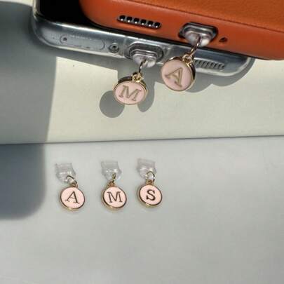 1 个防尘塞粉色吊坠，两侧带有 26 个英文首字母，兼容 Lightning 连接器，适用于所有手机