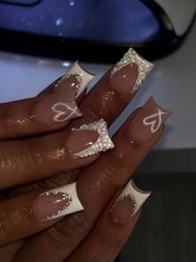 Set de 24 uñas postizas de longitud corta y forma cuadrada con puntas francesas blancas con recorte en forma de corazón, con incrustaciones de rhinestones y perlas, de alta brillo y autoadhesivas, incluye pegamento de gel y lima de uñas mini para bodas y uso diario