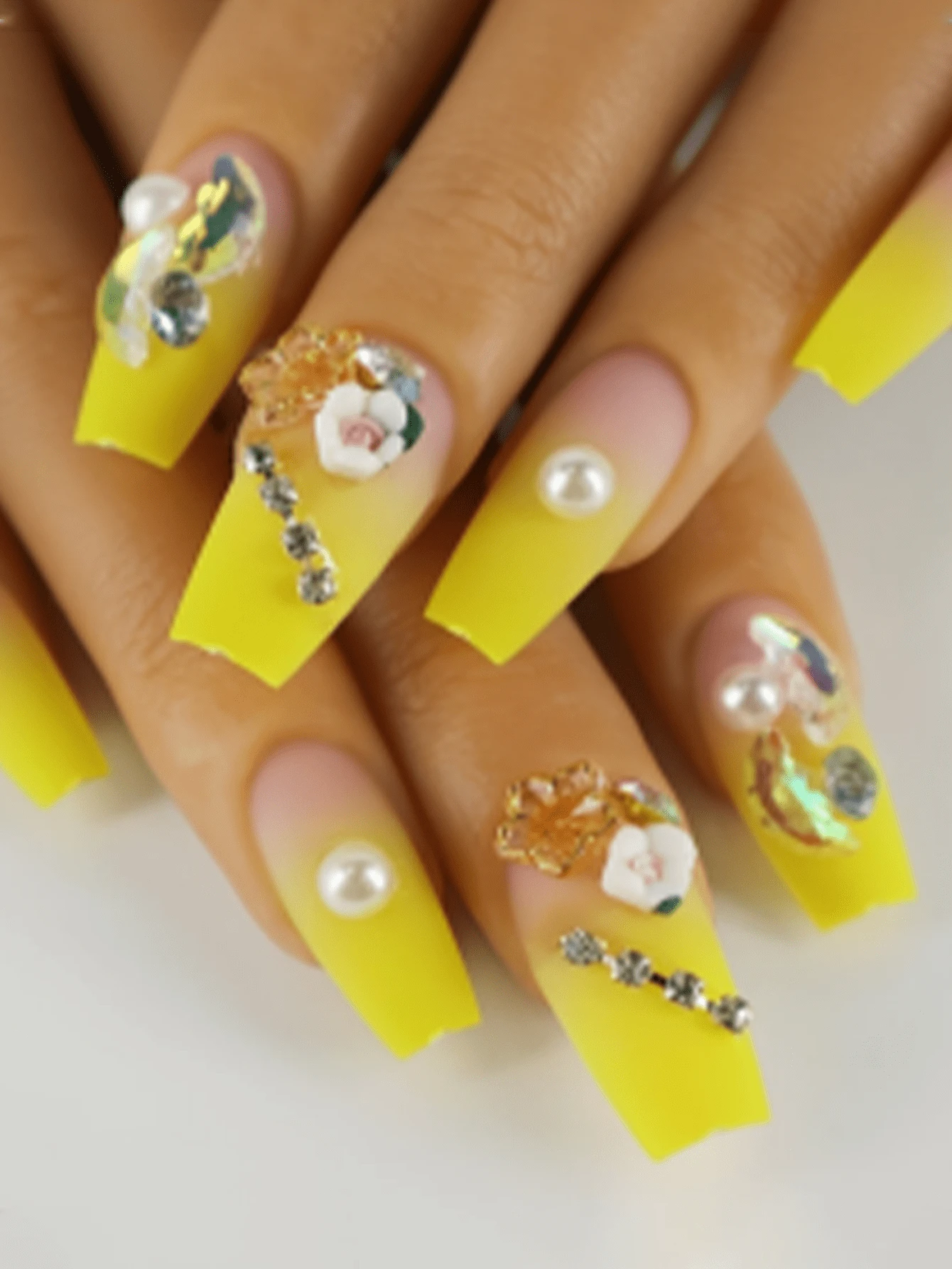 Bộ 24 móng tay giả Coffin màu lì quyến rũ mùa hè dài vừa phải. Móng tay giả màu vàng nắng rực rỡ có họa tiết hoa 3D và ngọc trai giả. Móng tay giả Ballerina sang trọng và lộng lẫy, thích hợp để trang trí móng hàng ngày cho phụ nữ. Bộ sản phẩm bao gồm một dũa móng, keo dán và một que tẩy móng. - Nhiều màu - Xem 1