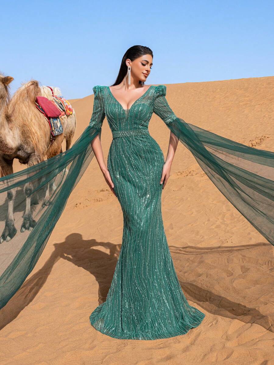 Faeriesty Đầm dạ hội trang trọng thanh lịch dành cho nữ với cổ chữ V sâu, tay áo dài chấm đất trong suốt ấn tượng và kiểu dáng đuôi cá tôn dáng. Được thiết kế cho các buổi dạ tiệc trang trọng, lễ trao giải, sự kiện từ thiện quan trọng, tiệc cưới và các buổi tiệc chiêu đãi sang trọng.
